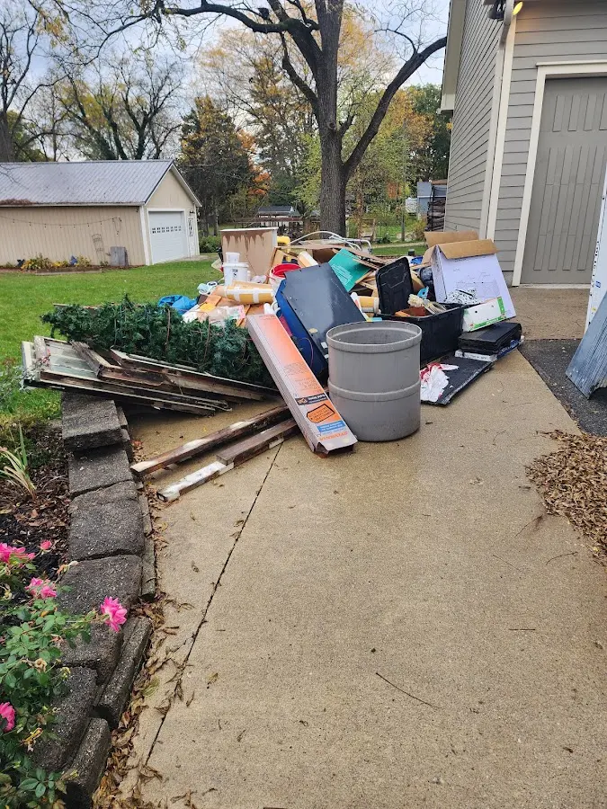 Dumpster being loaded with debris for Estate Cleanout Dumpster Rental in Iowa City